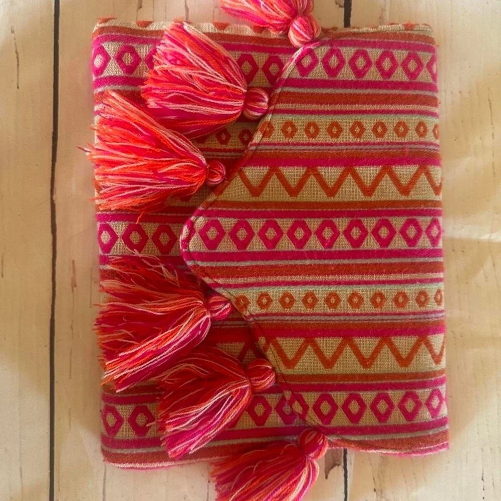 Mudpie Pink and orange embroidered geometric patterned clutch with tassels